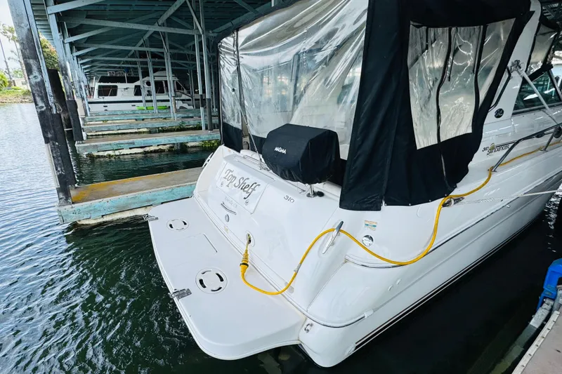 Slide: The Image of 2001 Sea Ray Sundancer 310 docked in a covered marina slip. - 15