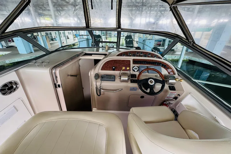 Slide: The Image of 2001 Sea Ray Sundancer 310 helm with steering wheel, controls, and gauges in a marina setting. - 24