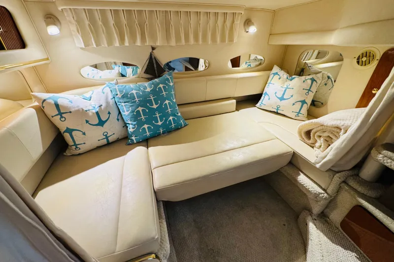 Slide: The Image of Interior of 2001 Sea Ray Sundancer 310 with anchor-themed pillows and cozy seating. - 34