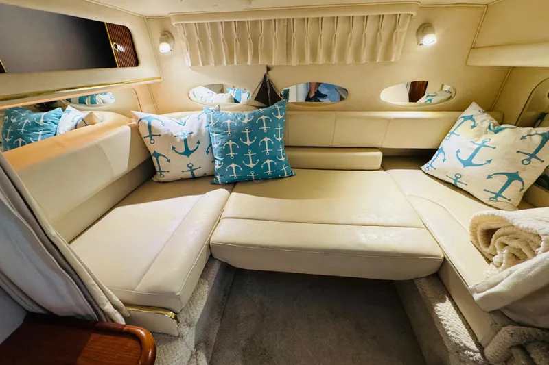 Slide: The Image of Interior of 2001 Sea Ray Sundancer 310 with cozy seating and nautical-themed pillows. - 35