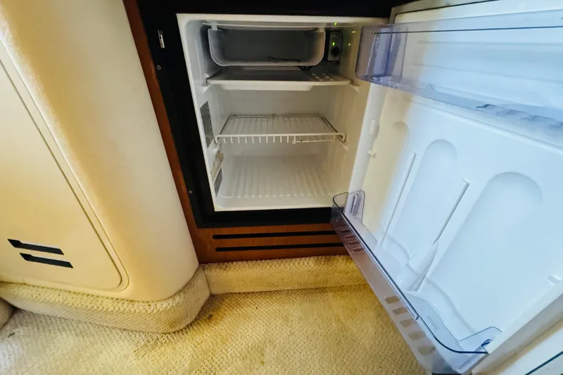 Slide: The Image of Open refrigerator inside 2001 Sea Ray Sundancer 310 yacht, showcasing interior storage space. - 40