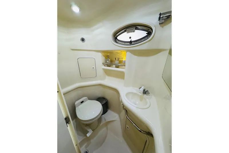 Slide: The Image of 2001 Sea Ray Sundancer 310 bathroom with toilet, sink, and porthole window. - 41