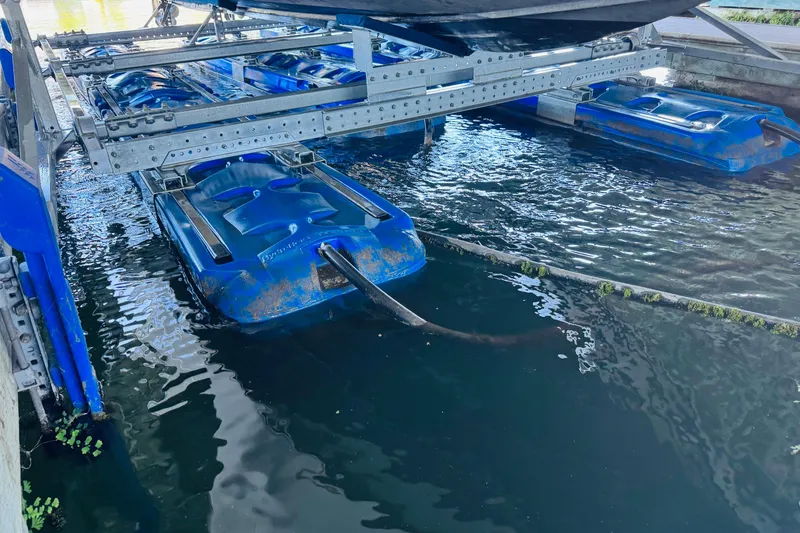 Slide: The Image of Boat lift system with blue pontoons under a Sea Ray Sundancer 310, 2001 model. - 57