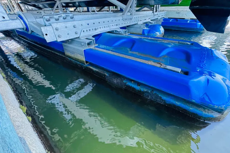 Slide: The Image of Blue HydroHoist boat lift supporting a 2001 Sea Ray Sundancer 310 in water. - 58