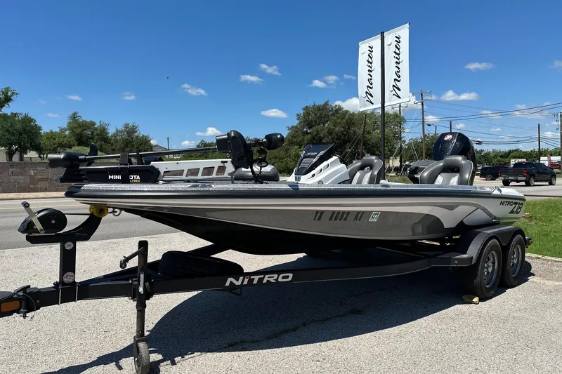 The Image of 2021 Nitro Z18 boat on trailer, parked outdoors under clear blue sky. - 0