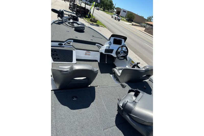 Slide: The Image of 2021 Nitro Z18 boat interior with steering console and seating, parked on roadside. - 13