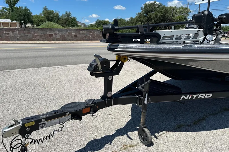 Slide: The Image of 2021 Nitro Z18 boat trailer with Minn Kota Ultrex motor on a sunny day. - 2