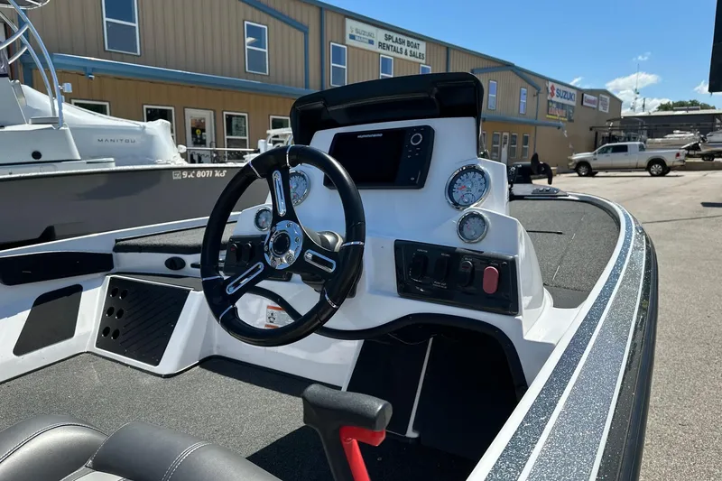 Slide: The Image of 2021 Nitro Z18 boat dashboard with steering wheel and gauges, parked near a boat rental shop. - 5