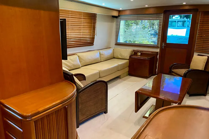 Slide: The Image of Interior of a 1986 Huckins Sport Fisherman yacht with elegant wood furnishings and beige seating. - 16