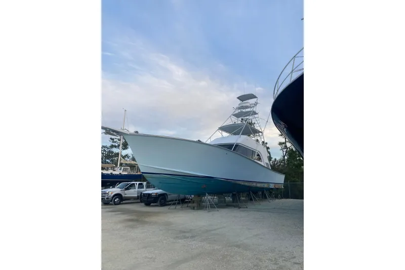 Slide: The Image of 1986 Huckins Sport Fisherman boat on dry dock, side view under clear sky. - 2