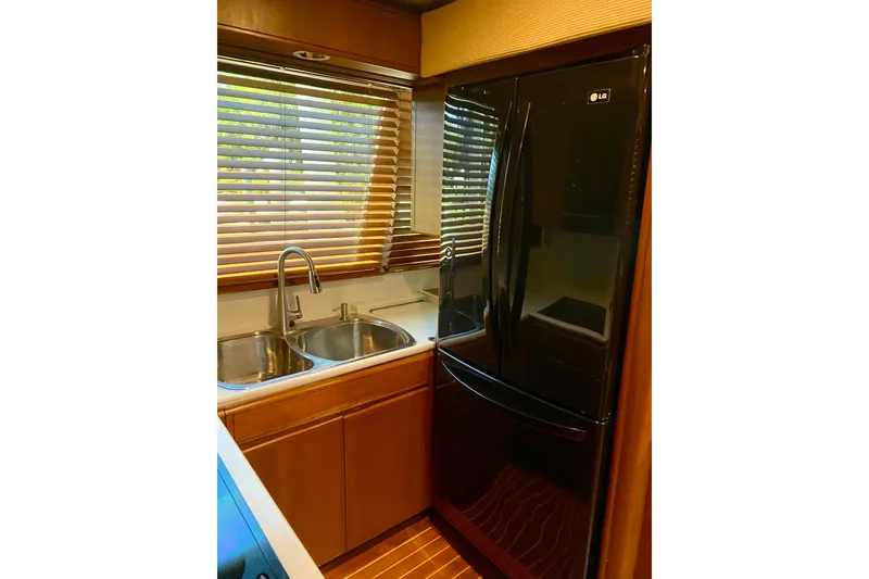 Slide: The Image of 1986 Huckins Sport Fisherman kitchen with double sink and black LG refrigerator. - 22