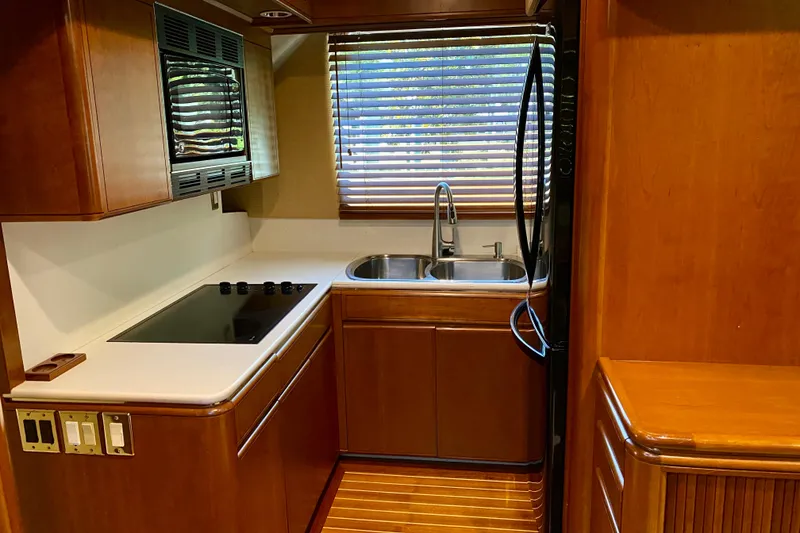 Slide: The Image of 1986 Huckins Sport Fisherman yacht kitchen with wood cabinetry and modern appliances. - 23