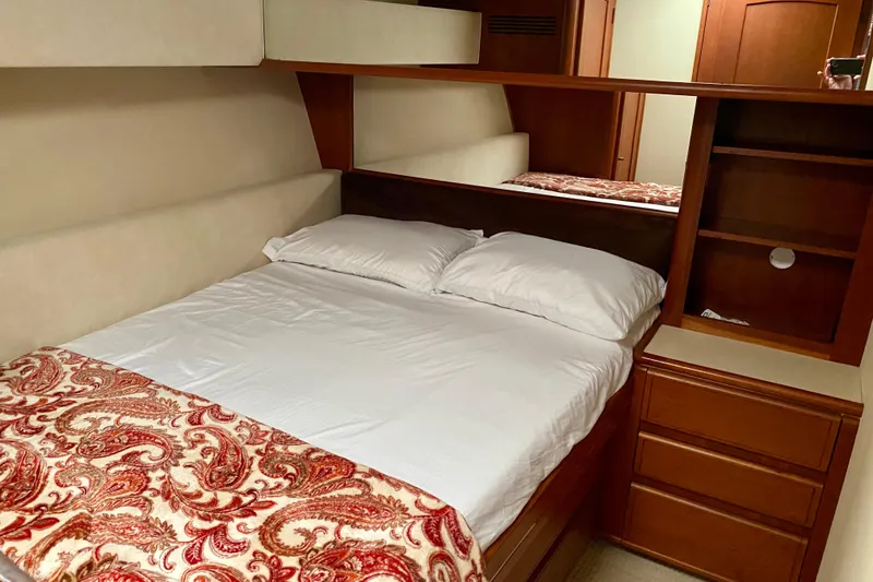 Slide: The Image of Cozy bedroom interior of 1986 Huckins Sport Fisherman yacht with wooden cabinetry. - 27