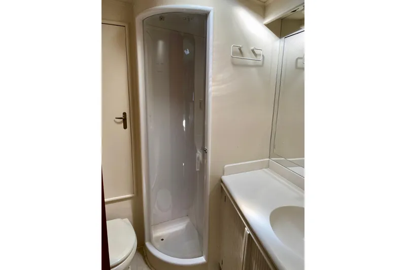 Slide: The Image of 1986 Huckins Sport Fisherman bathroom with shower, sink, and mirror. - 30