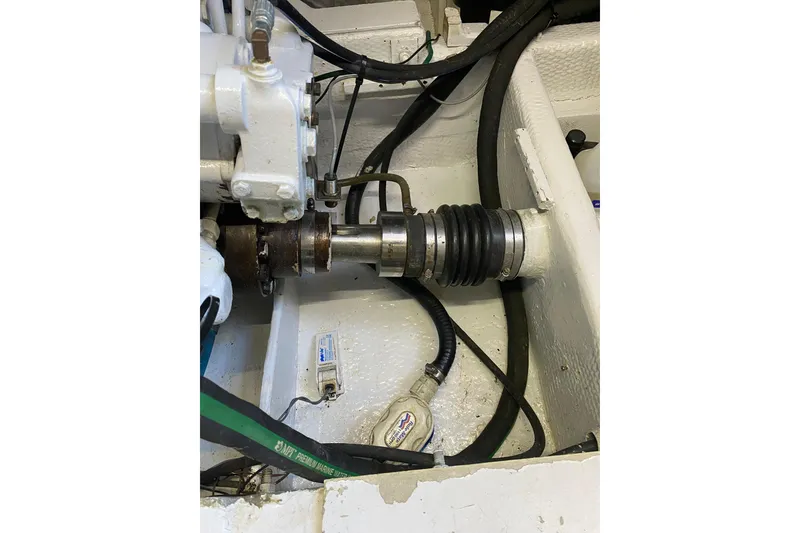 Slide: The Image of Engine compartment of a 1986 Huckins Sport Fisherman boat, showing mechanical components and hoses. - 36