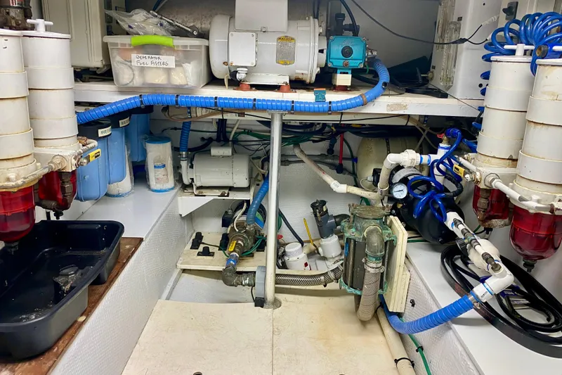Slide: The Image of Engine room of a 1986 Huckins Sport Fisherman with fuel filters and blue hoses. - 37