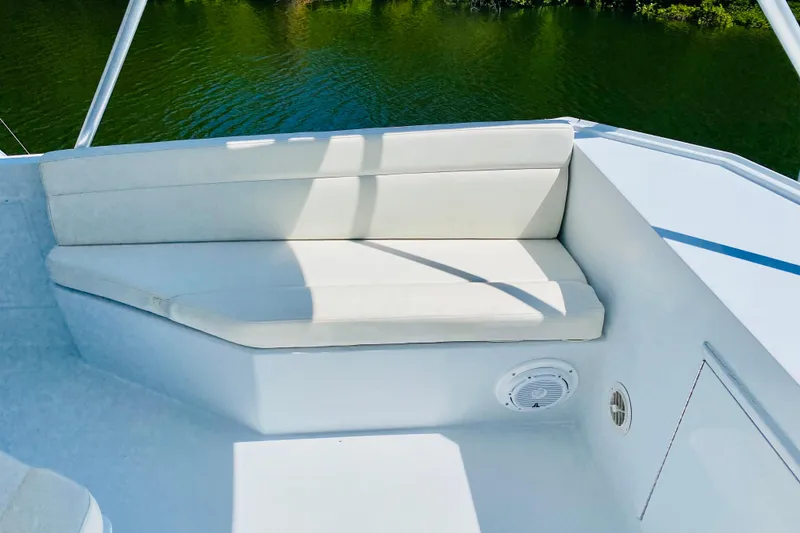 Slide: The Image of 1986 Huckins Sport Fisherman boat seating area with white cushions and water view. - 5