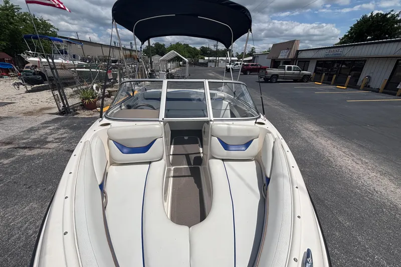 Slide: The Image of 2003 Bayliner 185 Capri boat with blue and white interior, parked outdoors. - 12