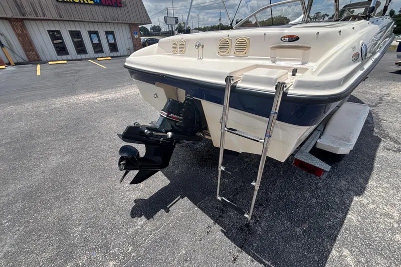 Slide: The Image of 2003 Bayliner 185 Capri boat with ladder and Mercury outboard motor in parking lot. - 15