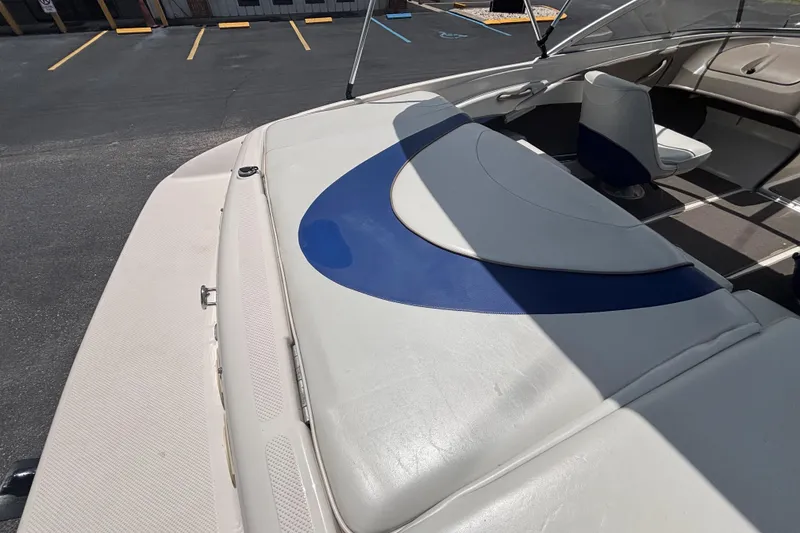 Slide: The Image of 2003 Bayliner 185 Capri boat interior with blue and white seating in a parking lot. - 16