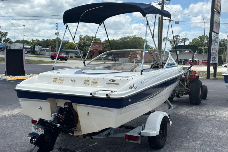 Slide: The Image of 2003 Bayliner 185 Capri boat on trailer with canopy, parked outdoors. - 5