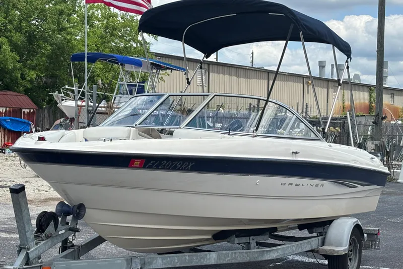 Slide: The Image of 2003 Bayliner 185 Capri boat on trailer with canopy, parked outdoors. - 9
