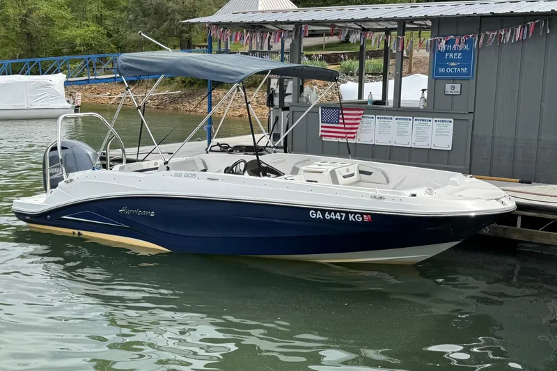 The Image of 2022 Hurricane SunDeck Sport 205 OB boat docked at a marina with American flag. - 0