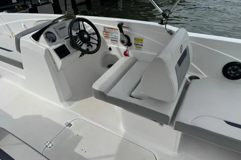 Slide: The Image of 2022 Hurricane SunDeck Sport 205 OB boat interior with steering wheel and seating. - 6