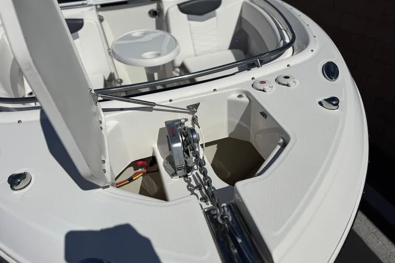 Slide: The Image of 2022 Robalo R247 Dual Console boat anchor compartment with seating and table. - 11
