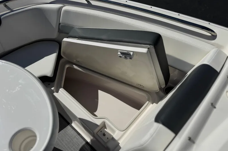 Slide: The Image of 2022 Robalo R247 Dual Console boat interior with open storage compartment and seating. - 16