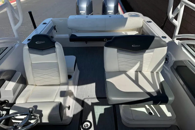 Slide: The Image of 2022 Robalo R247 Dual Console boat interior with white seating and steering wheel. - 24