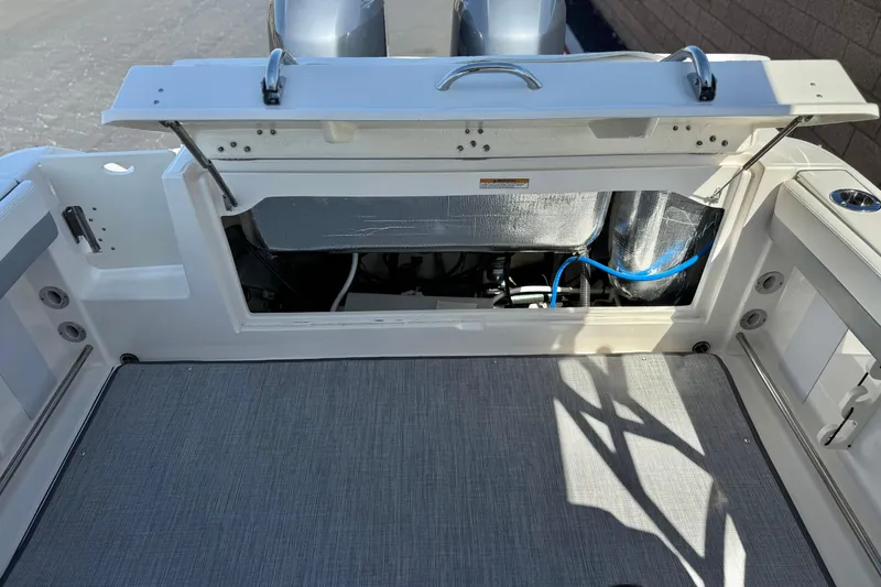 Slide: The Image of 2022 Robalo R247 Dual Console boat with open engine compartment, showcasing interior details. - 27
