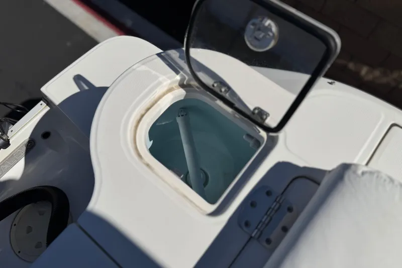 Slide: The Image of 2022 Robalo R247 Dual Console boat livewell with open lid, showcasing interior details. - 32