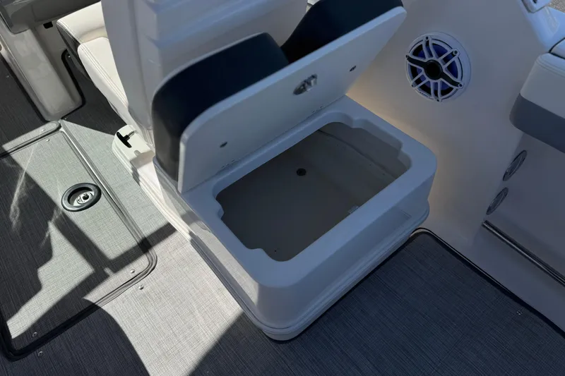 Slide: The Image of 2022 Robalo R247 Dual Console boat interior with open storage compartment and speaker. - 36