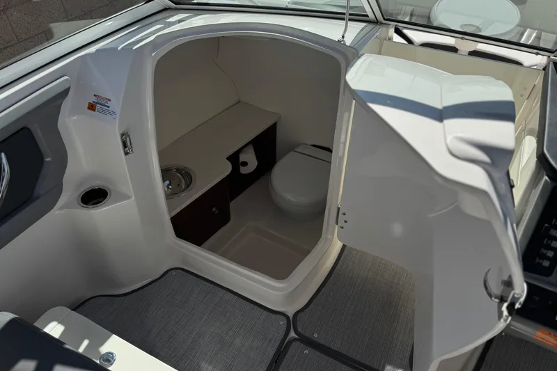Slide: The Image of 2022 Robalo R247 Dual Console boat interior with compact bathroom and sink. - 38
