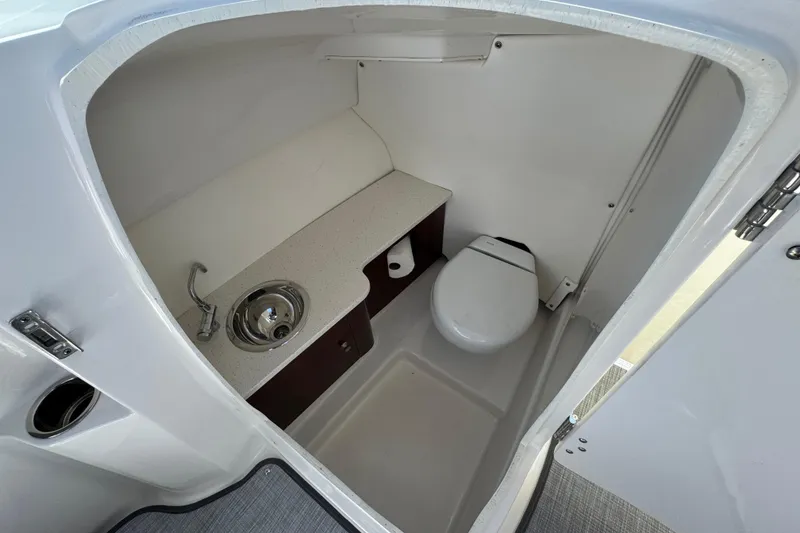 Slide: The Image of 2022 Robalo R247 Dual Console boat interior with compact bathroom and sink. - 39