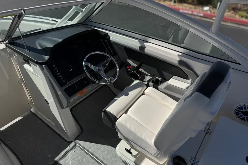 Slide: The Image of 2022 Robalo R247 Dual Console boat interior with steering wheel and seating. - 41