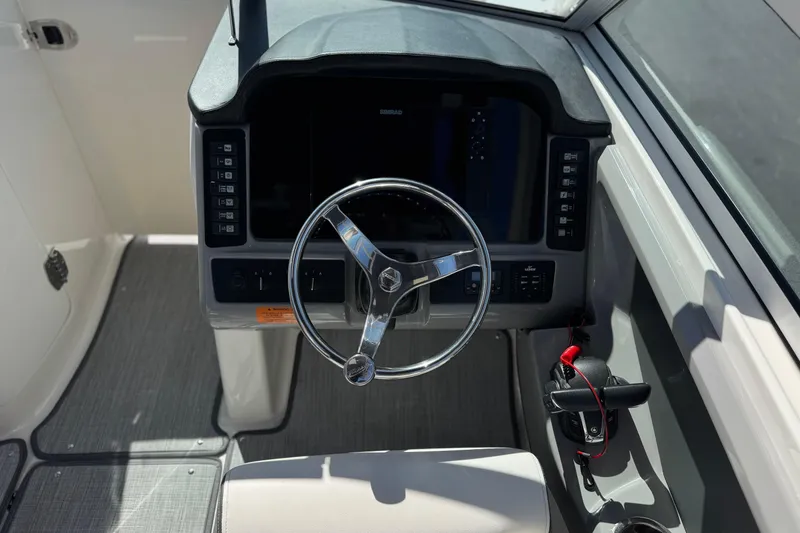 Slide: The Image of 2022 Robalo R247 Dual Console boat helm with steering wheel and control panel. - 42