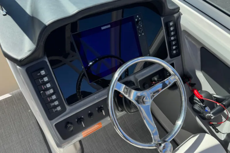 Slide: The Image of 2022 Robalo R247 Dual Console boat dashboard with steering wheel and control panel. - 43