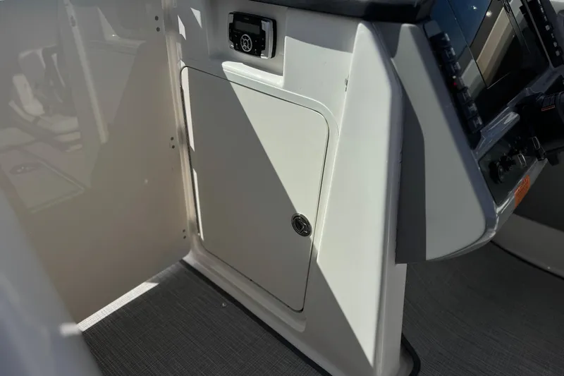 Slide: The Image of 2022 Robalo R247 Dual Console interior with control panel and storage compartment. - 45