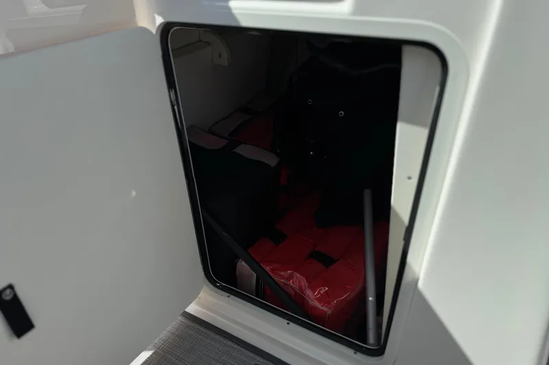 Slide: The Image of Storage compartment in 2022 Robalo R247 Dual Console boat, featuring life jackets. - 46