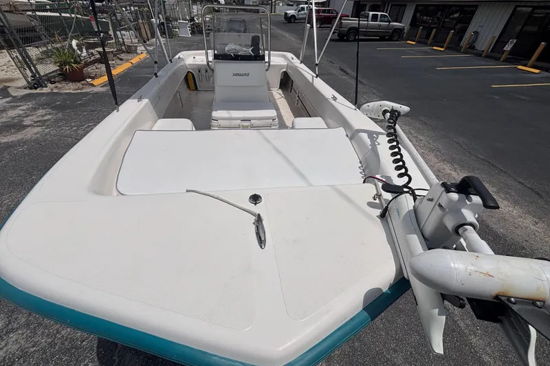 Slide: The Image of 2008 Sundance B18CC boat with open deck and seating, parked in a lot. - 10