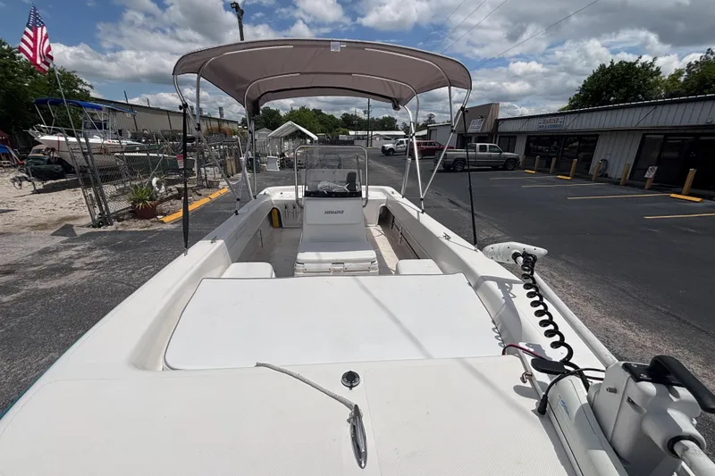 Slide: The Image of 2008 Sundance B18CC boat with canopy, parked outdoors under a cloudy sky. - 11