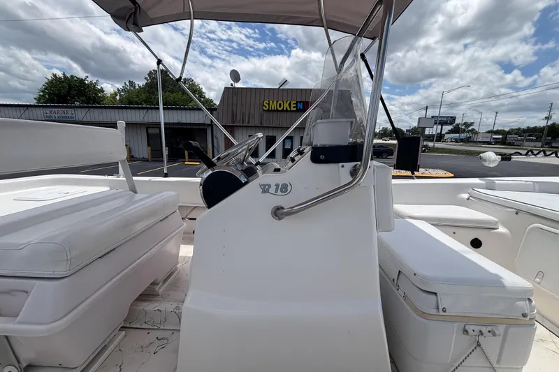 Slide: The Image of 2008 Sundance B18CC boat interior with steering console and seating under cloudy sky. - 13