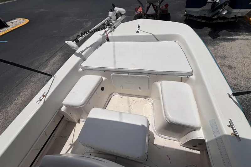 Slide: The Image of 2008 Sundance B18CC boat interior with white seating and storage compartments. - 17