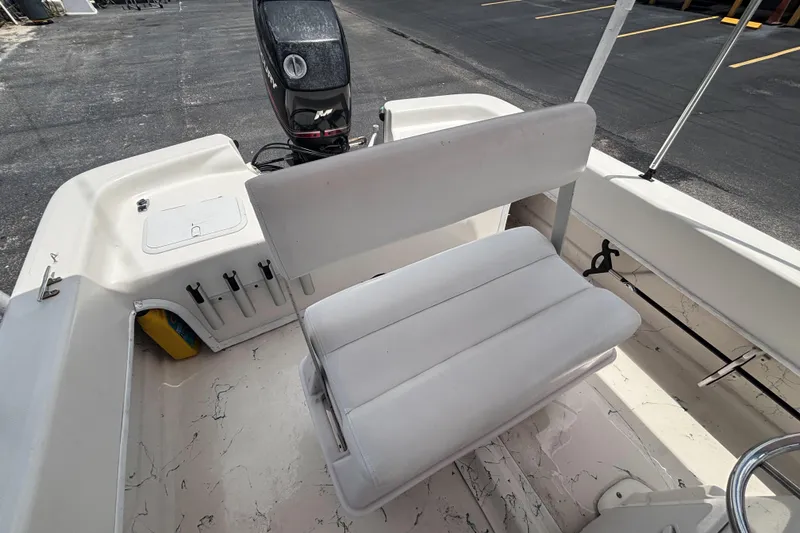 Slide: The Image of 2008 Sundance B18CC boat interior with white seating and Mercury outboard motor. - 20
