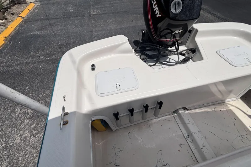 Slide: The Image of 2008 Sundance B18CC boat with Mercury outboard motor, docked on asphalt surface. - 21