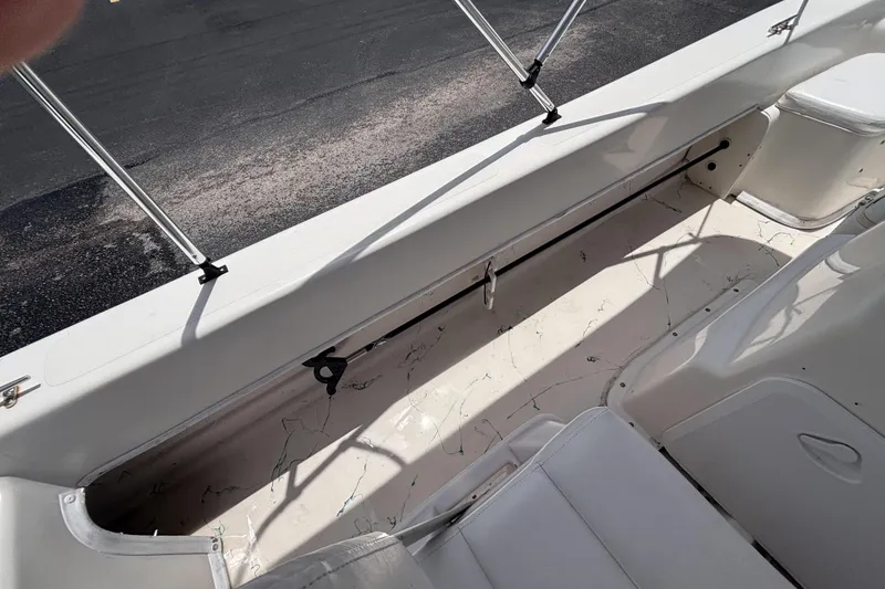 Slide: The Image of 2008 Sundance B18CC boat interior with white seating and storage compartment. - 26