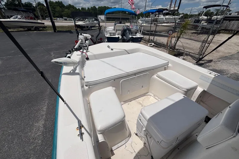 Slide: The Image of 2008 Sundance B18CC boat interior with seating and storage, docked at a marina. - 28