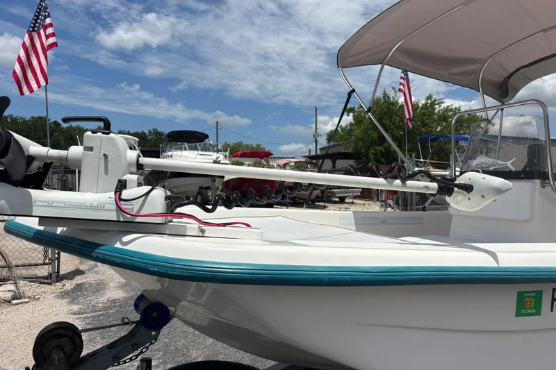Slide: The Image of 2008 Sundance B18CC boat with trolling motor, parked outdoors under a clear sky. - 33